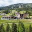 Mountain hotel surrounded by trees and green meadows